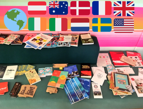 A range of print written by children is laid out underneath flags of Europe